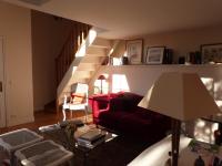 a living room with a red couch and stairs at L&#39;Orangerie White-Palacio in Versailles