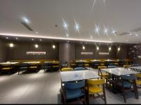 ein Esszimmer mit Tischen und gelben Stühlen in der Unterkunft Hanting Nanjing Xingang Development Zone Second Branch in Nanjing