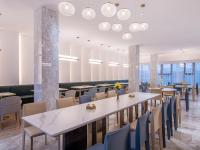 een restaurant met tafels, stoelen en verlichting bij Orange Chengdu Jinniu Wanda Hotel in Chengdu