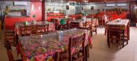 a dining room with tables and chairs and red walls at JR Hotel in João Pessoa