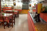 a restaurant with tables and chairs and a counter at JR Hotel in João Pessoa