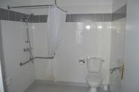 a white bathroom with a toilet and a shower at Hôtel Restaurant Le Bellevue in Ax-les-Thermes