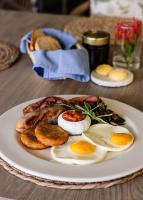 a plate of food with eggs and bread on a table at Diaz Ocean View Hotel & Spa in Mossel Bay