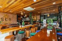 a restaurant with wooden tables and stools at Wellness Resort Rayong Managed by the SCN in Ban Huai Pla Kang