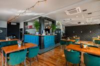 米科瓦伊基Kurort Kameralny的一间设有蓝色桌子和绿色椅子的餐厅