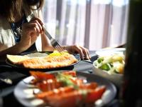 a woman is eating food with a fork and knife at KOS Pilar Hotel in Pilar