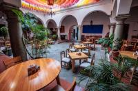 a restaurant with wooden tables and chairs and plants at Hotel Posada Casa de la Tía in Oaxaca City