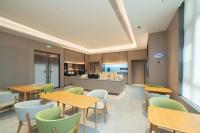 ein Esszimmer mit Tischen und Stühlen und eine Küche in der Unterkunft JI Hotel Shanghai Jinshan Industrial Zone in Jinshan