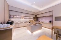 eine große Küche mit weißen Schränken und einem Tisch in der Unterkunft JI Hotel Shanghai Xuhui Riverside in Shanghai