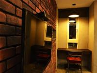 a room with a brick wall and a table and chairs at Hotian Inn in Donggang