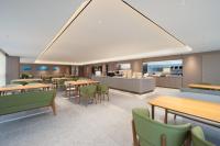 a restaurant with tables and chairs and a cafeteria at JI Hotel Hangzhou Xiaoshan Chaoyang Subway Station in Hangzhou