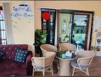 un salon avec un canapé, une table et des chaises dans l'établissement Home stay Ev Coffeehouse, à Ban Map Khao Wan