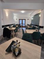 Un comedor con mesas y sillas y una pizarra. en Pensiunea Kalinder, en Buşteni
