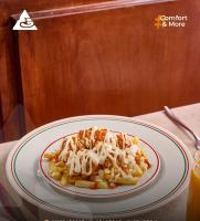 einen Teller Pasta mit Soße und Käse auf dem Tisch in der Unterkunft Arafa Hotel - فندق عرفه الجديد in Tanta