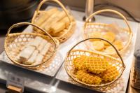 trois paniers de pain et de bananes sur un comptoir dans l'établissement Hanting Hotel Shanghai Jiaotong University Jiangchuan Road Subway Station 2, à Shanghai