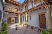 a courtyard with a large building with wooden doors and potted plants at Multi Apartamentos La Kasbah in Jerez de la Frontera