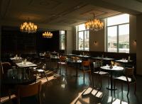 Un comedor con mesas, sillas y candelabros. en Le Royal Plaza, en Kenitra