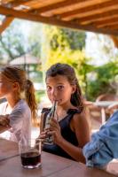 Una niña sentada en una mesa bebiendo una bebida en La Granja de Antonio, en Alhaurín el Grande
