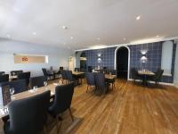 a restaurant with wooden floors and tables and chairs at Westend Hotel & Bar in Nairn