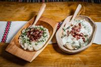 Twee kommen met eten op een houten tafel, met lepels erbij. bij Hotel U dobrého pastiera in Ružomberok