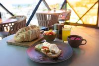 a plate with a sandwich and a bowl of fruit on a table at Prixma Hotel in San Andrés