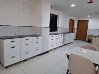 een kantoor met witte kasten, een tafel en stoelen bij Hotel Kamla Palace in Vrindāvan