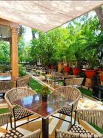 een terras met een tafel, stoelen en planten bij Hotel Vimal Heritage in Jaipur