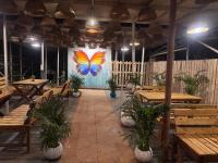 a restaurant with tables and a butterfly painting on the wall at BRAMHA COTTAGES in Canacona