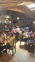 a group of people sitting at tables in a restaurant at Hotel y Restaurante Mi Bohio in Diriamba