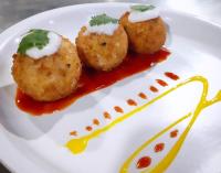 Hotel Lenexa by Bestinn Leisure في بانغالور: طبق يحتوي على ثلاث كرات لحم مع صلصة وصلصة