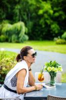 a woman sitting at a table with a drink at Eco Nieborów in Nieborów