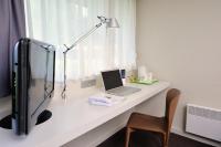 a desk with a laptop and a lamp and a chair at Campanile Valence Sud in Valence