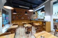 ein Restaurant mit Holztischen und Stühlen und Lichtern in der Unterkunft Le Petit in Bratislava