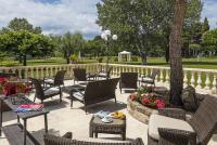 een patio met stoelen en tafels in een park bij Mas de Guilles in Lourmarin