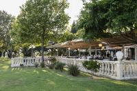 een restaurant in een park met een wit hek bij Mas de Guilles in Lourmarin