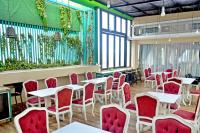 een restaurant met witte tafels en rode stoelen bij Alodia Powered by Archipelago in Tanjungkarang