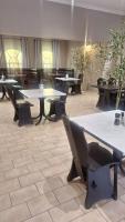 una habitación con mesas y sillas en un edificio en Mariental Hotel Cc, en Mariental