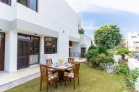 een patio met een tafel en stoelen op het gras bij Jobner Haus Jaipur in Jaipur