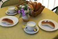 una mesa con platos y tazas de café y una cesta de pan en Bonacic Palace, en Slatine