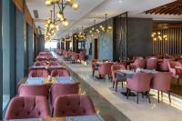 un comedor con mesas y sillas rosas en Greenwood Suites Resort, en Lara