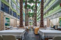 ein Restaurant mit Palmen im Flur in der Unterkunft Shanshui Trends Hotel - Huaqiangbei in Shenzhen