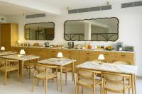 een keuken met tafels en stoelen en twee spiegels bij Hotel Boutique Petit París in Port de Pollença