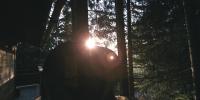 a person is standing in front of some trees at Cabane entre terre et ciel in Saint-Nicolas-la-Chapelle