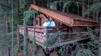 two people in a tree house in the forest at Cabane entre terre et ciel in Saint-Nicolas-la-Chapelle