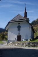 a small white church with a steeple and a cross at Cabane entre terre et ciel in Saint-Nicolas-la-Chapelle