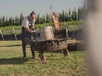 Een man in een schort die naast een grill staat. bij Bodega Iaccarini Wine Lodge by BT Homes in San Rafael