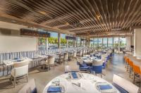 a dining room with white tables and blue chairs at Living Water Resort & Spa in Collingwood