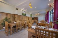 un ristorante con tavoli e sedie in legno in una stanza di Echor Himalayan Retreat Ranikhet a Rānīkhet