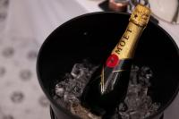 eine Flasche Wein in einem schwarzen Eimer in der Unterkunft RUELLE Chateau Boutique in Sinaia