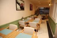 una sala da pranzo con tavoli in legno e sedie bianche di Rush Hotel Tokat a Tokat